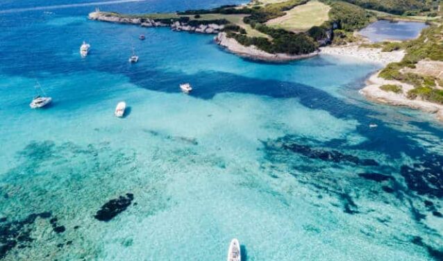 Eau turquoise avec des bateaux, plage en Corse